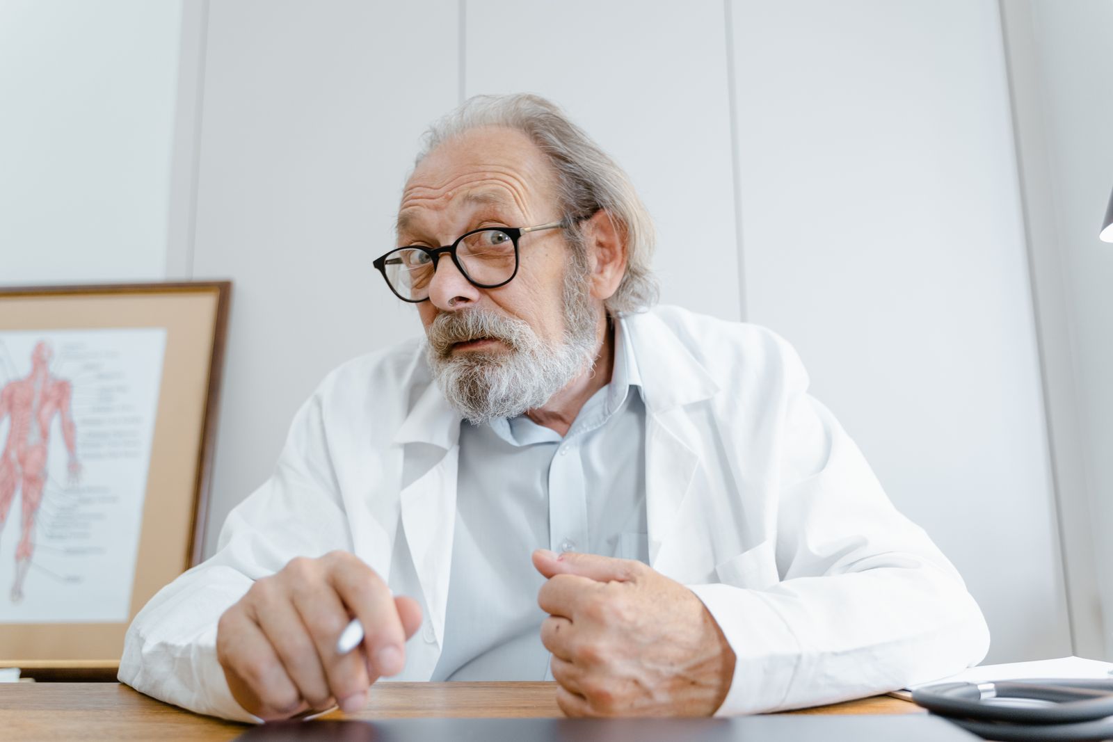 A clinician in a white coat seated in a medical office