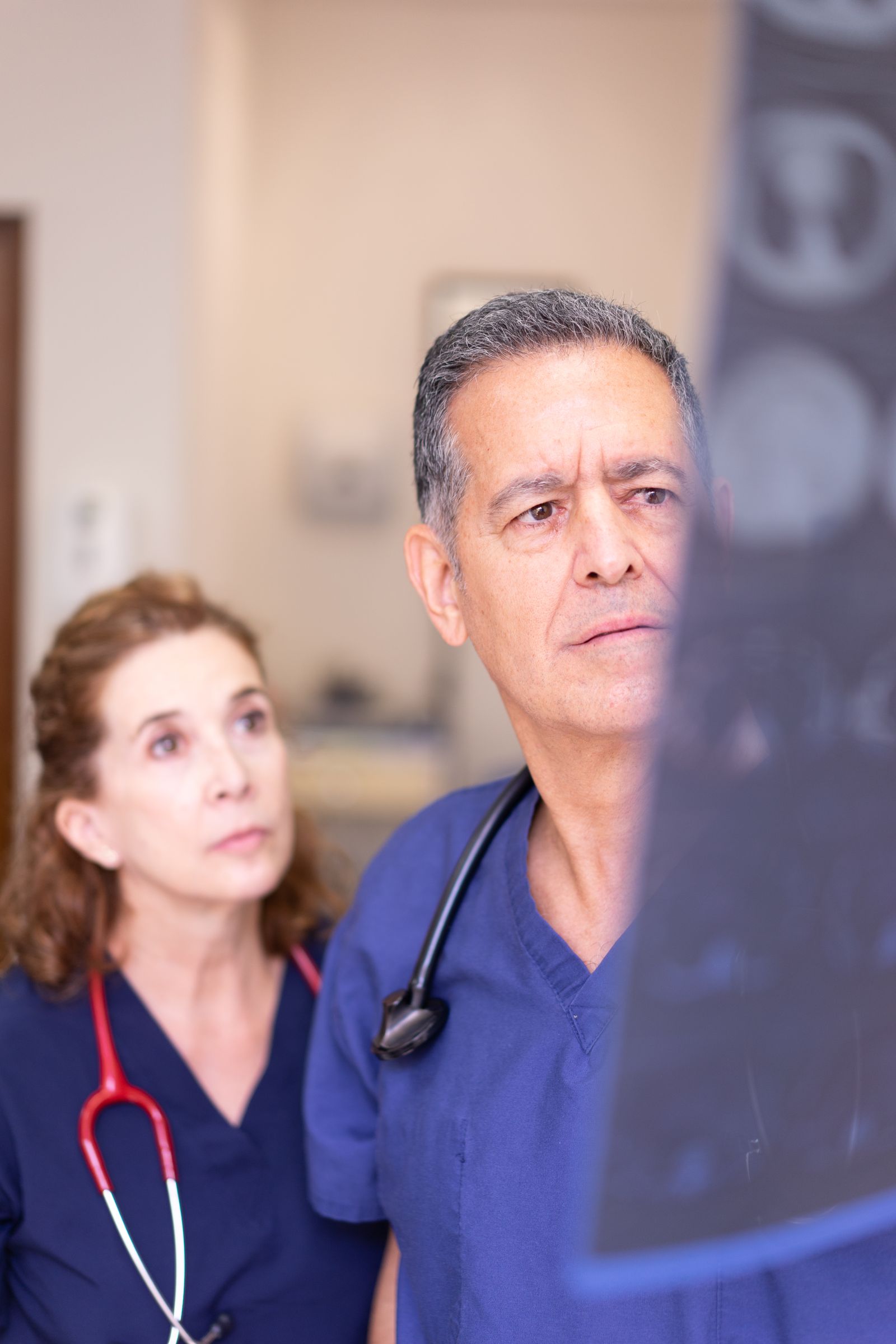 Two clinicians in scrubs looking at an x-ray in a hospital