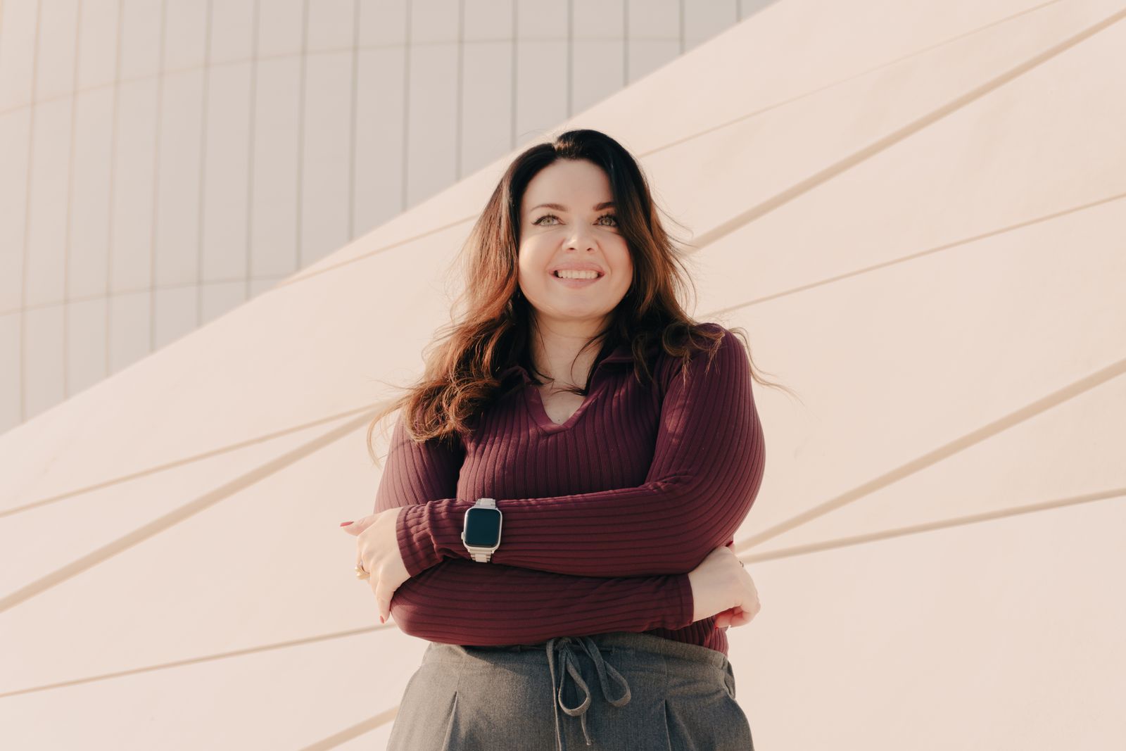 An adult smiling outdoors in sunlight