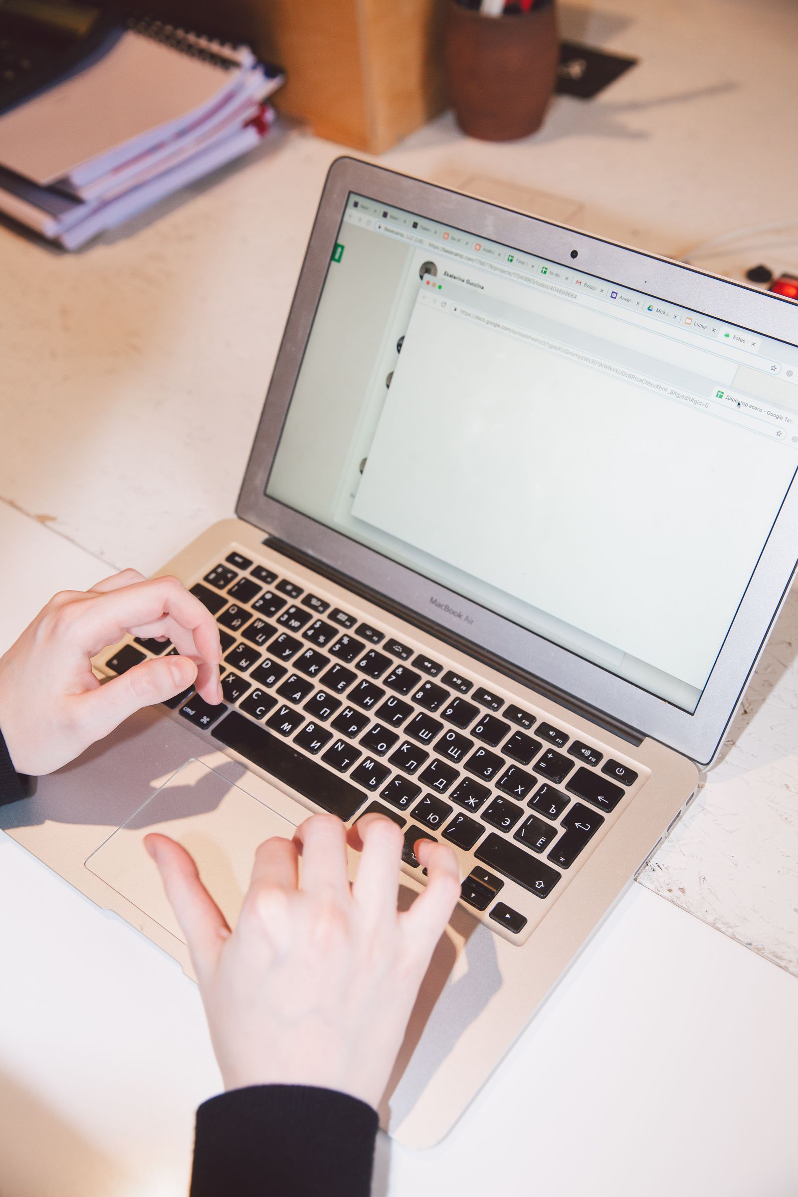 Hands using a laptop at a private desk
