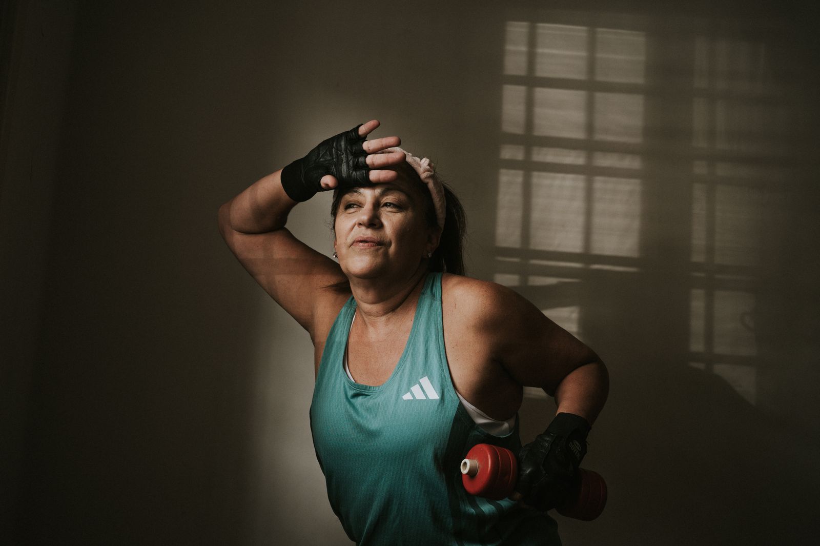 An adult exercising with dumbbells at home