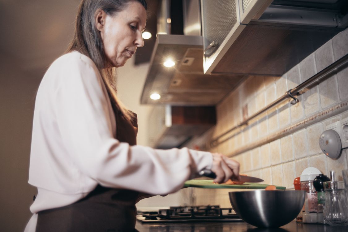 An adult preparing fresh food in a home kitchen